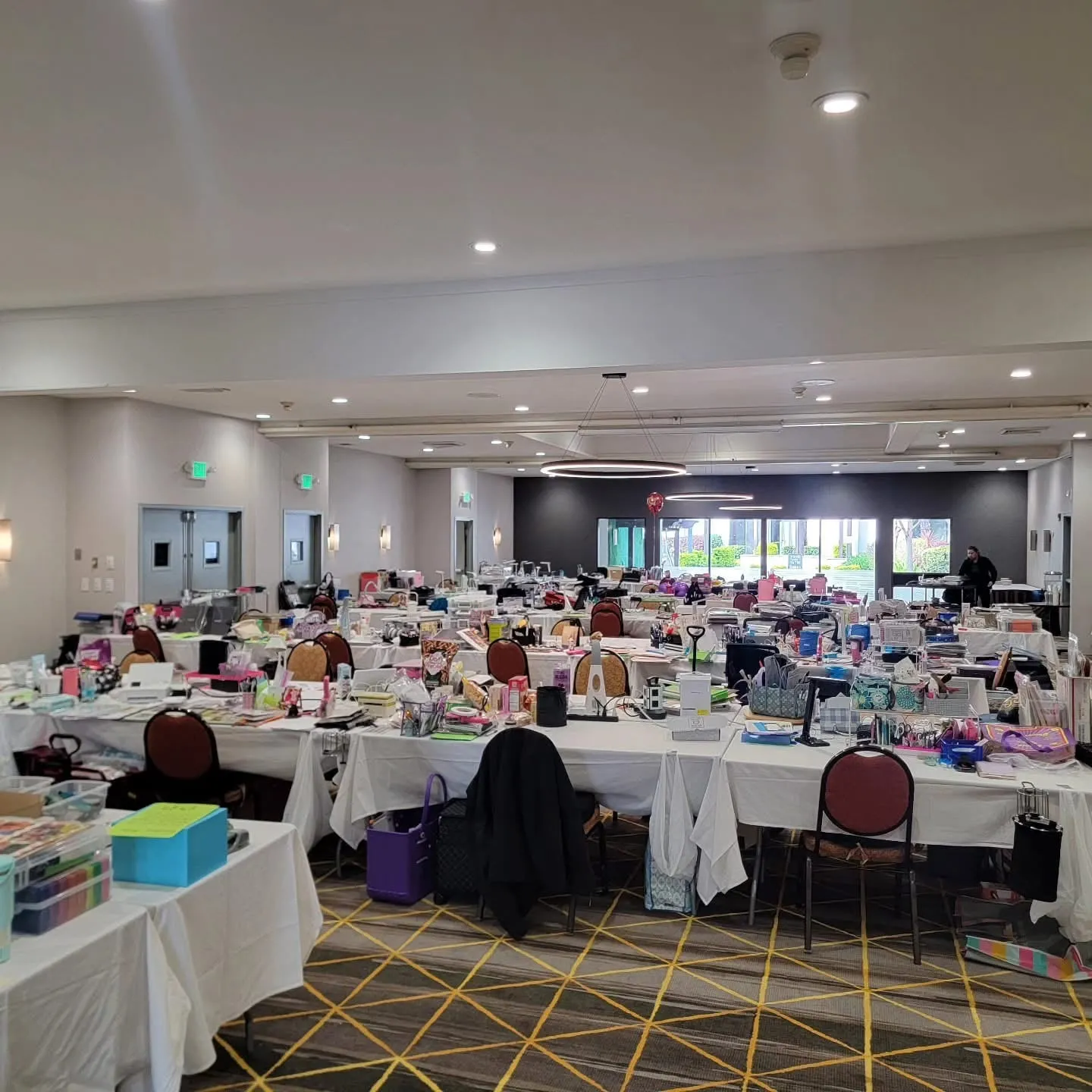 The crop room set and ready: rows of white-clothed six-foot tables loaded with supplies before the weekend begins